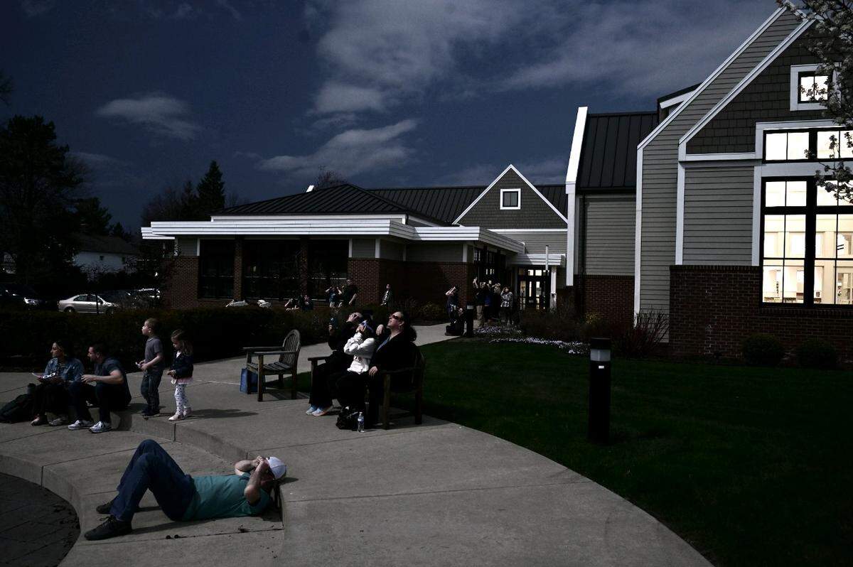 Viewers look at the solar eclipse Monday during an event held at the Canfield branch of the Youngstown and Mahoning County Library.