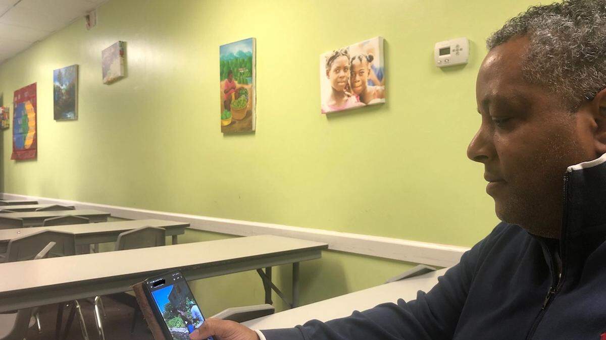 Attorney FritzGerald Tondreau, who helps with immigration issues at Konbit Neg Lakay in Spring Valley, N.Y., shows intimidating videos of gang hostages and enemies being killed or beaten in Haiti. As a new wave of immigrants fleeing chaos arrives, many are moving beyond New York and Florida to find jobs and housing.