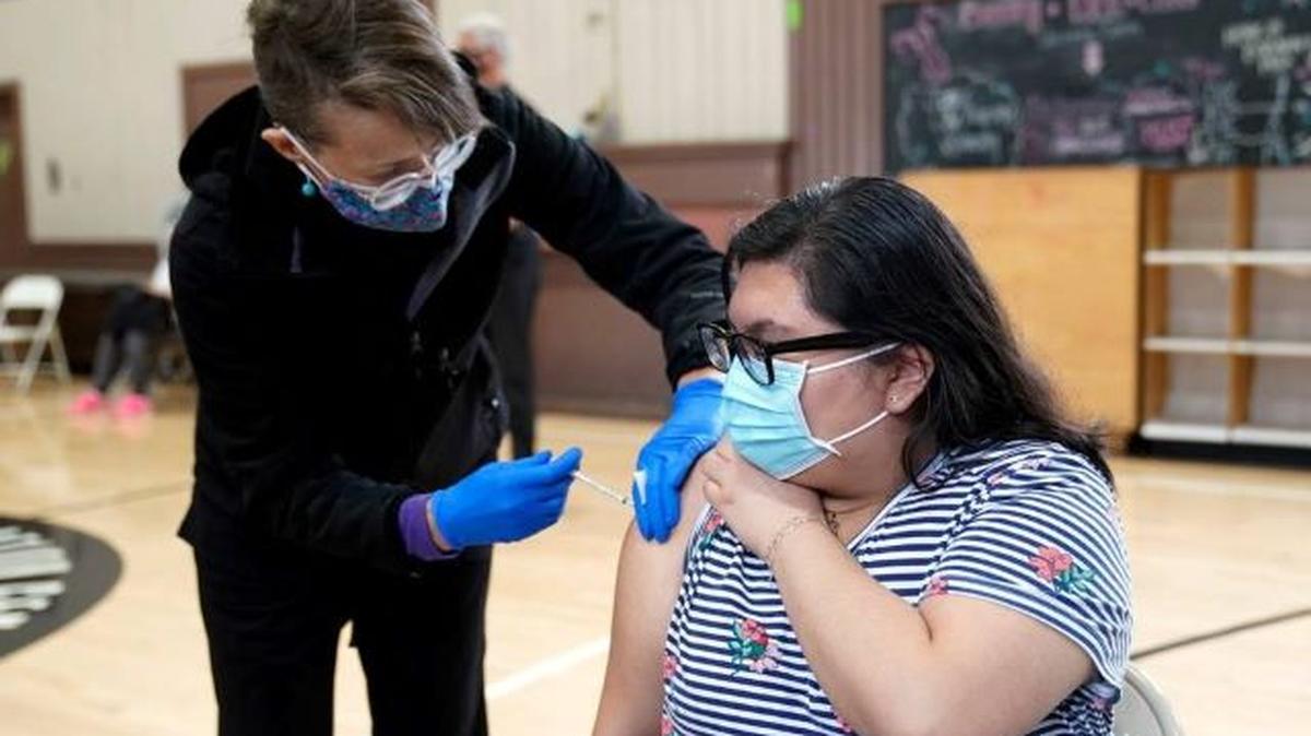 Esselen Reza, right, receives a dose of the Pfizer COVID-19 vaccine at the Banning Recreation Center in Wilmington, Calif., on April 13. People wh have had COVID-19 may feel stronger side effects after the first dose rather than second compared with people with no infection history. (Marcio Jose Sanchez | AP)