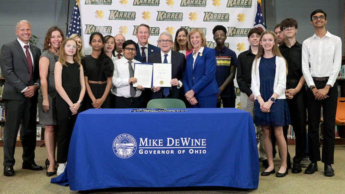 Gov. Mike DeWine signs House Bill 250 at Karrer Middle School in Dublin.