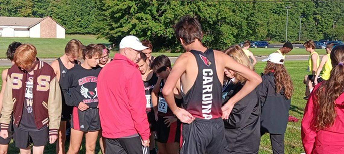 Canfield head cross country coach Eric O’Brien, left, talks to members of the Cardinals’ boys’ cross country team before their race at Saturday’s Boardman Spartan Invitational held on the grounds of Boardman High School.