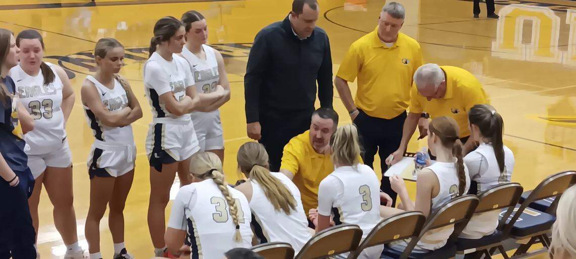 United girls’ head basketball coach Cory Leek, center bottom, talks to his team during a timeout in Monday night’s first-place Eastern Ohio Athletic Conference showdown with Columbiana in the Golden Eagles gym.