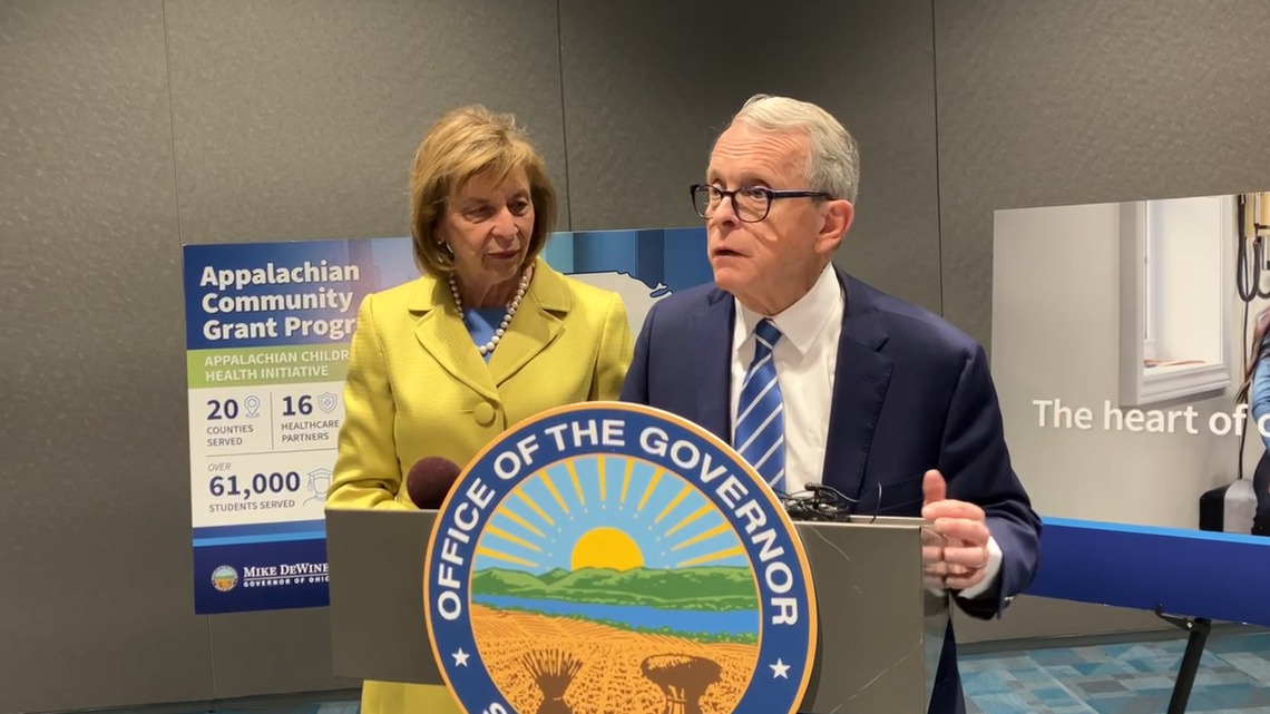 Ohio Gov. Mike DeWine talks with reporters Friday following a press conference in Campbell. Standing beside him is Ohio First Lady Fran DeWine.