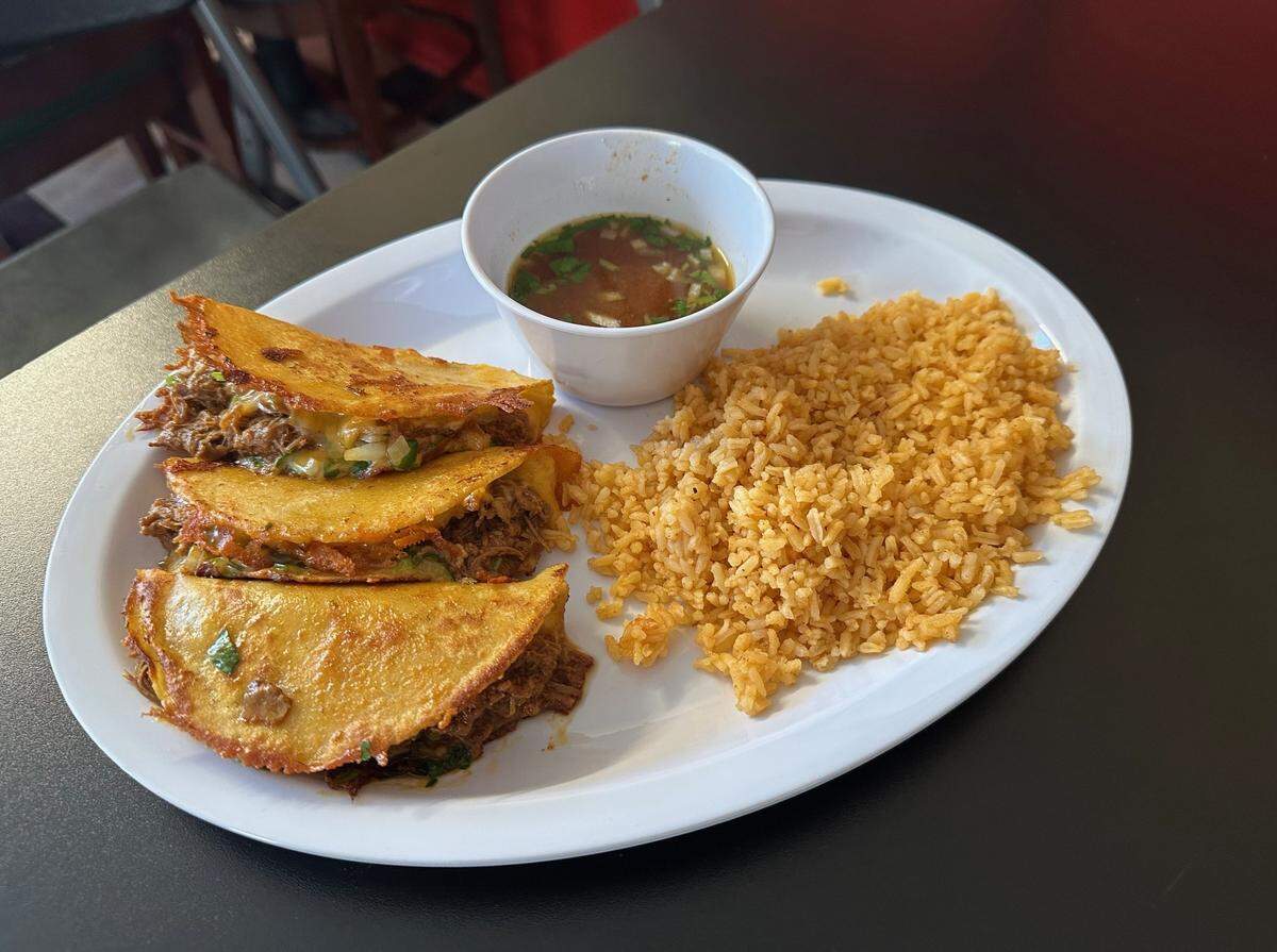 One of the top-selling items on the Taqueria Don Julio menu is the #7, which features three street tacos with shredded beef and a flavorful dipping sauce.