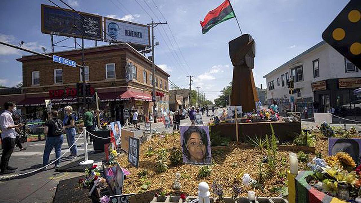 People walk through George Floyd Square in Minneapolis on Tuesday after shots were fired on the one-year anniversary of George Floyd's death. The intersection was disrupted by gunfire just hours before it was to be the site of a family-friendly street festival marking the anniversary of Foyd’s death at the hands of police. (Christian Monterrosa | AP Photo)