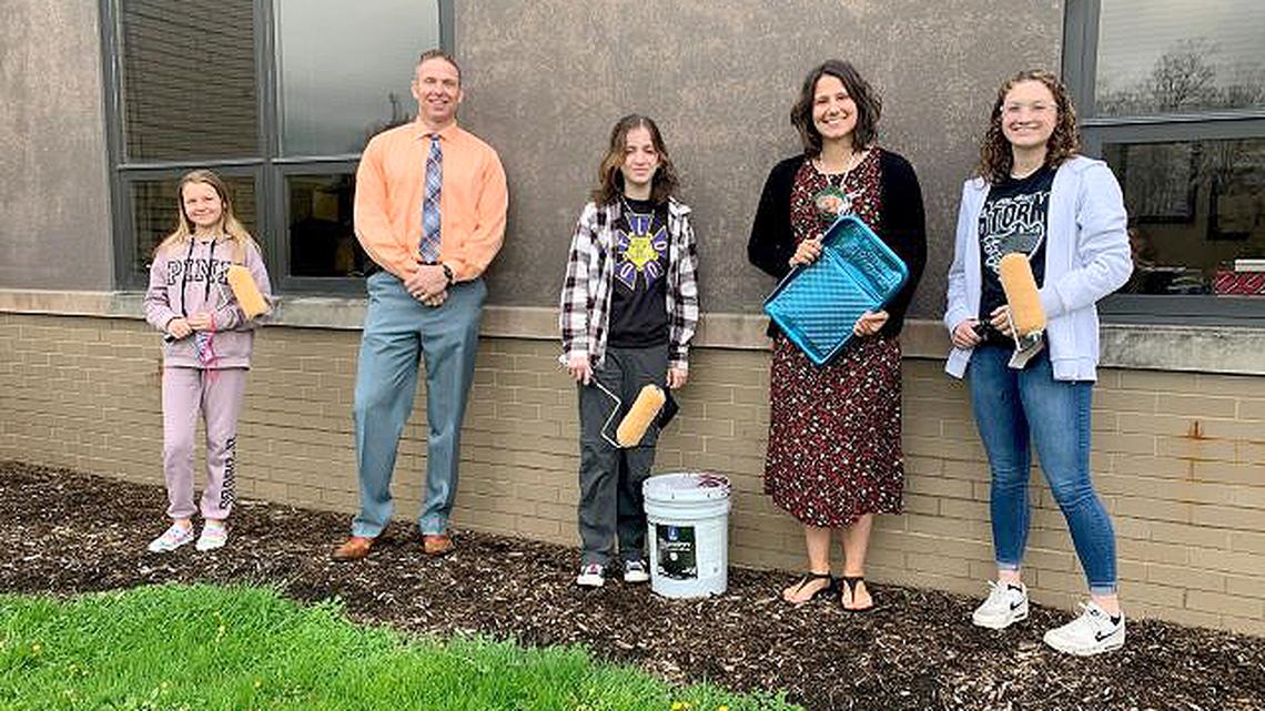 Students and staff are painting panels on the outside of Glenwood Junior High School for a Global Youth Service Day project. Shown here, from left, are Mary Malone; Principal Bart Smith; Lucy Papini; Laura Frost, Student Leadership advisor; and Alex Ward. (Contributed photo)