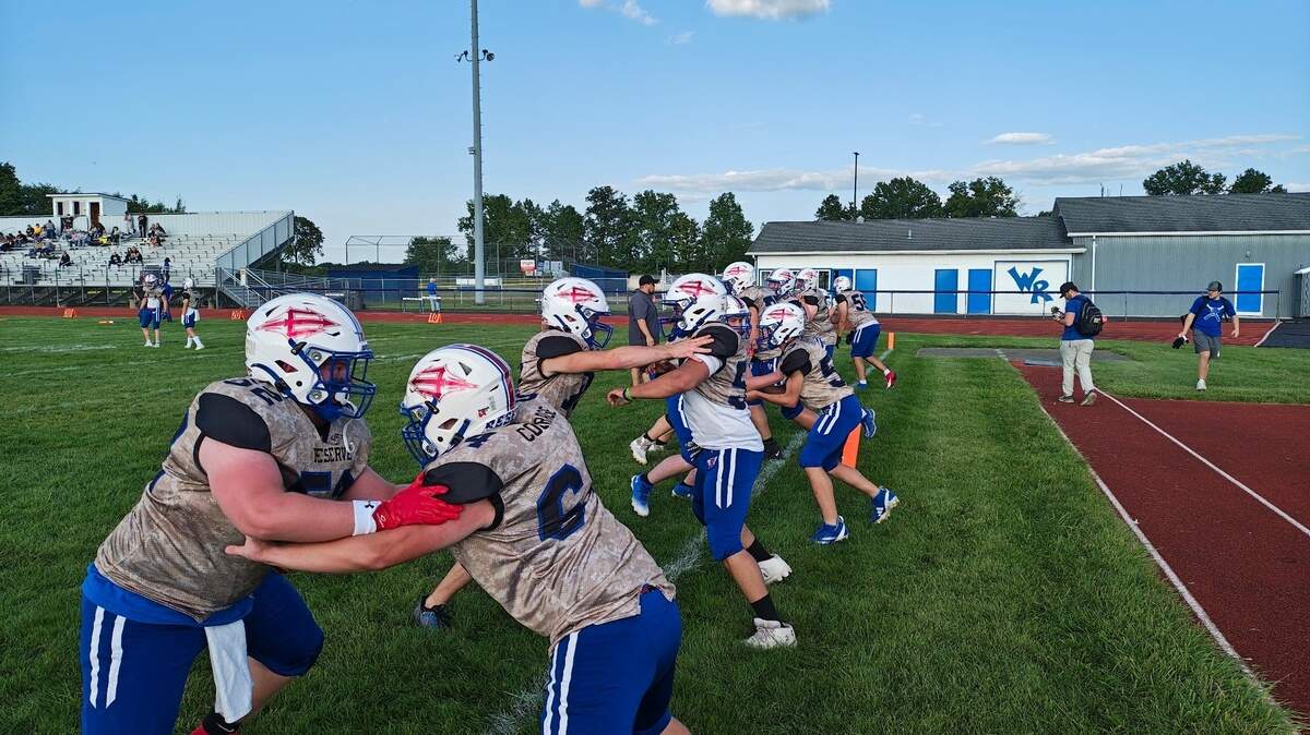 Western Reserve players, wearing special camo jerseys, warm up prior to Thursday night’s Military Night season-opening football game against Crestview at Western Reserve.