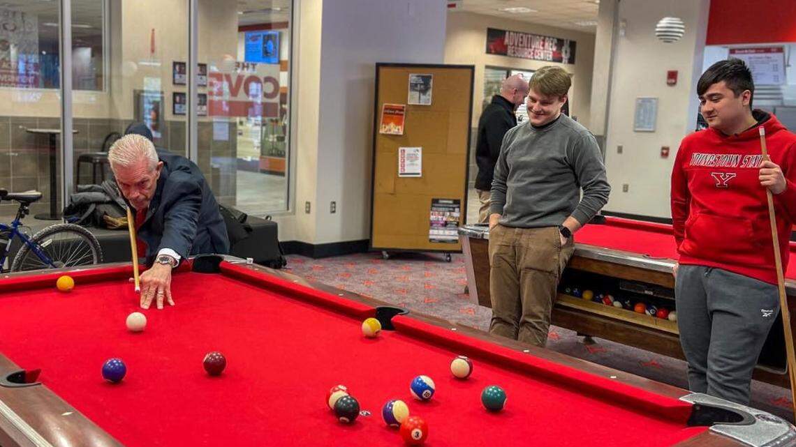 New Youngstown State University President Bill Johnson plays pool on Monday with several students.