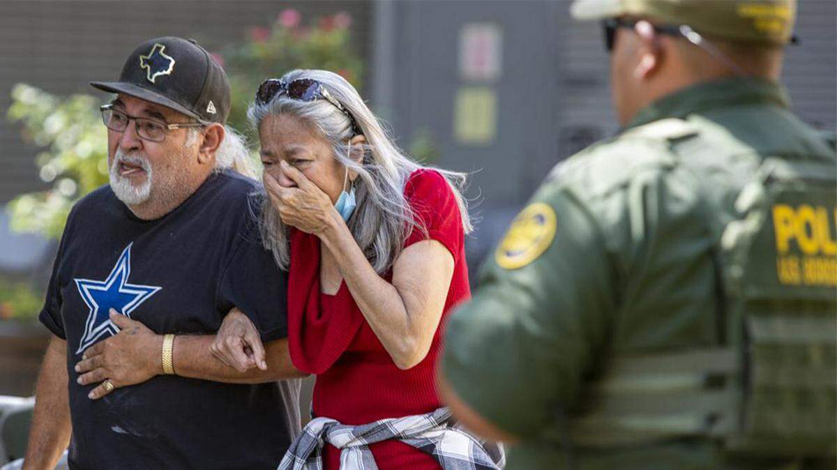 A woman cries as she leaves the Uvalde Civic Center in Uvalde, Texas, on Tuesday after an 18-year-old gunman opened fire at a Texas elementary school, killing at least 18 children and three adults.