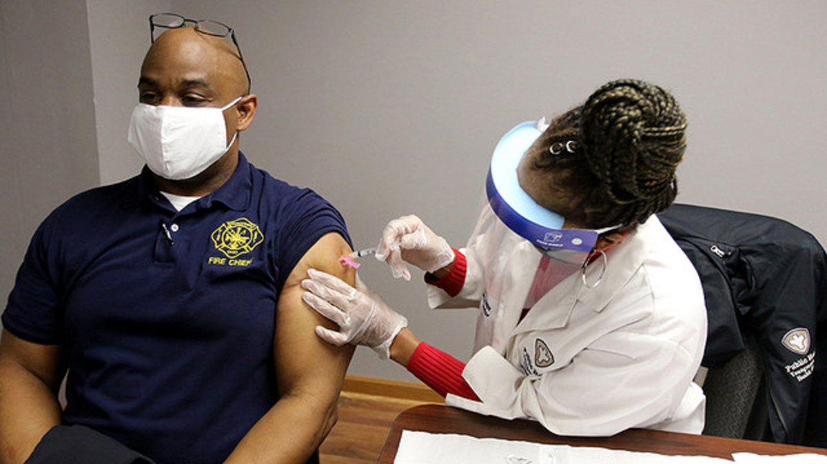 Nurse Anthea Mickens administers a COVID-19 vaccine to Youngstown Fire Department Chief Barry Finley today at Youngstown Fire Station 1. (Photo by Robert K. Yosay | Mahoning Matters)