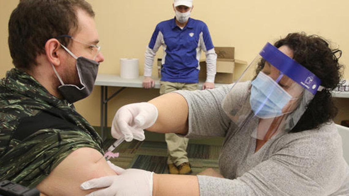 Youngstown City Health District nurse Theresa Sanchez (right) administers a dose of the coronavirus vaccine to Joseph Taylor, a Gateways to Better Living group home resident, during a city-run vaccination clinic Thursday, Dec. 31, 2020 at the Eugenia Atkinson Recreation Center along Otis Street in Youngstown.