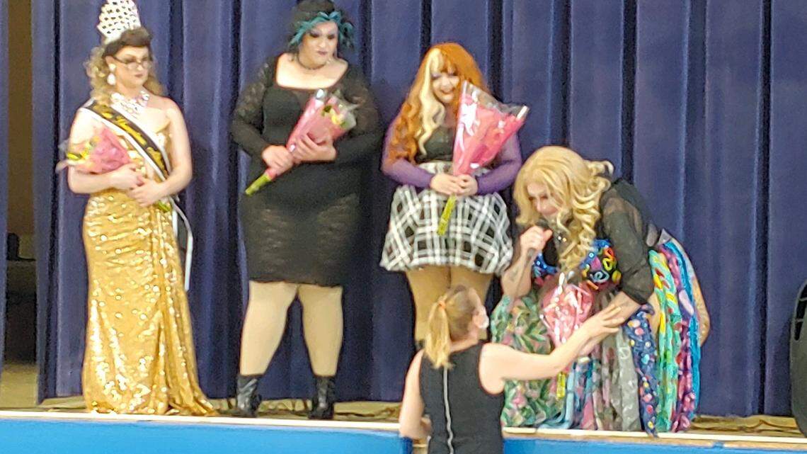 Youngstown teacher Mary Hall, below, greets four drag queen performers at a fundraiser for her on Saturday.