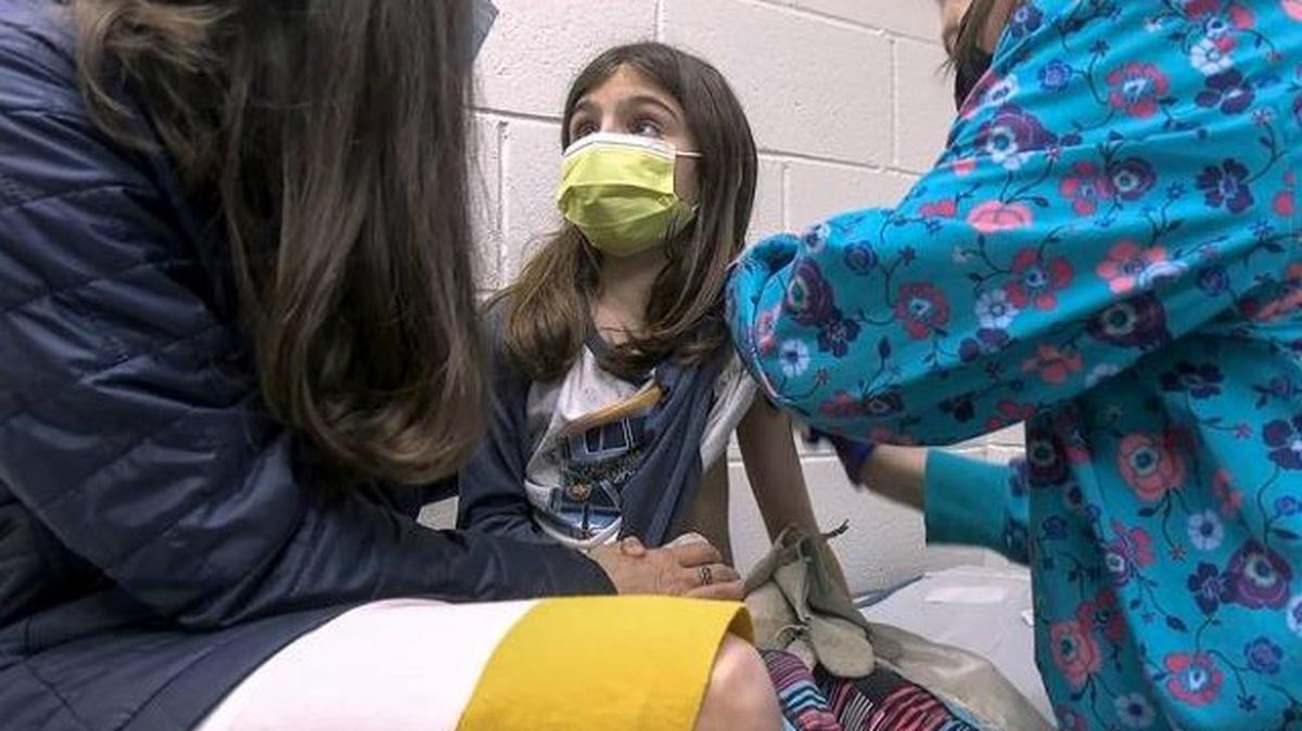 Alejandra Gerardo, 9, looks up to her mother, Susanna Naggie, as she gets the first of two Pfizer COVID-19 vaccinations during a clinical trial for children at Duke Health. (Shawn Rocco | Duke Health)