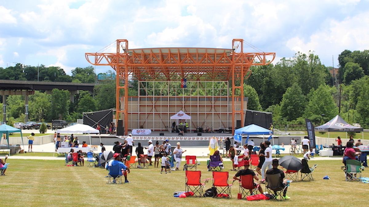 About 300 sat on the grass listening to music while vendors line the sidewalk at the Juneteenth celebration on Saturday in Youngstown (Photo by Ellen Wagner).
