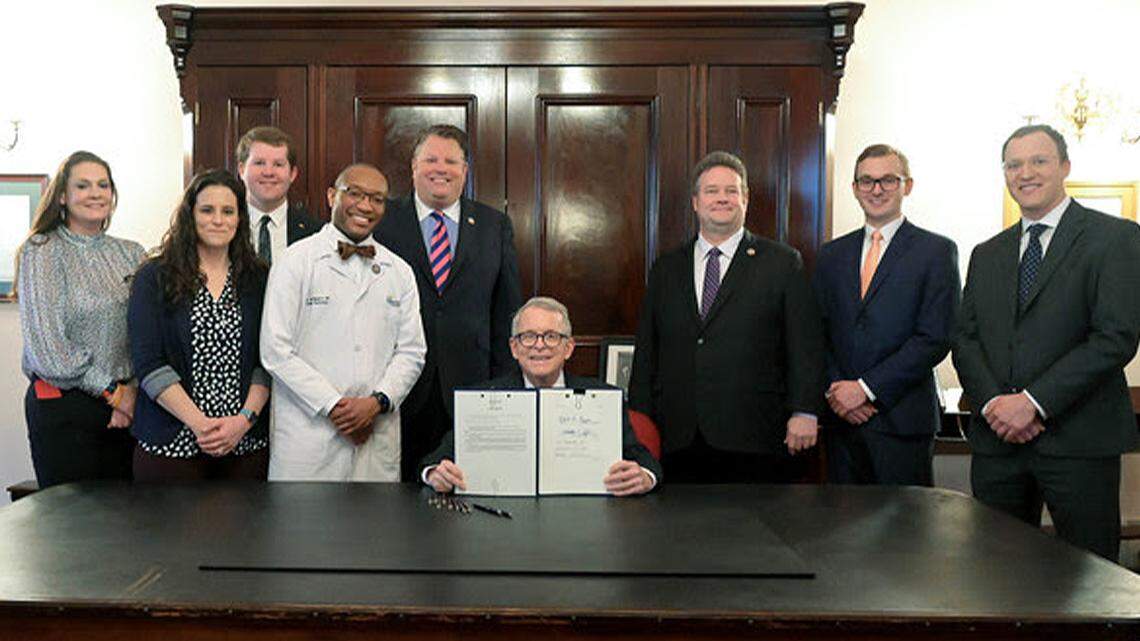 Gov. Mike DeWine, center, signed House Bill 188 into law at the Statehouse in Columbus on Wednesday.
