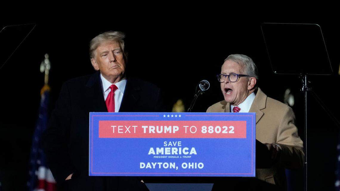 VANDALIA, OHIO - NOVEMBER 07:  Former U.S. President Donald Trump (L) looks on as Ohio Gov. Mike DeWine speaks at a rally for Ohio Republicans at the Dayton International Airport on November 7, 2022 in Vandalia, Ohio. Trump is campaigning for Republican candidates, including U.S. Senate candidate JD Vance, who faces U.S. Rep. Tim Ryan (D-OH) in tomorrow’s general election.  (Photo by Drew Angerer/Getty Images)