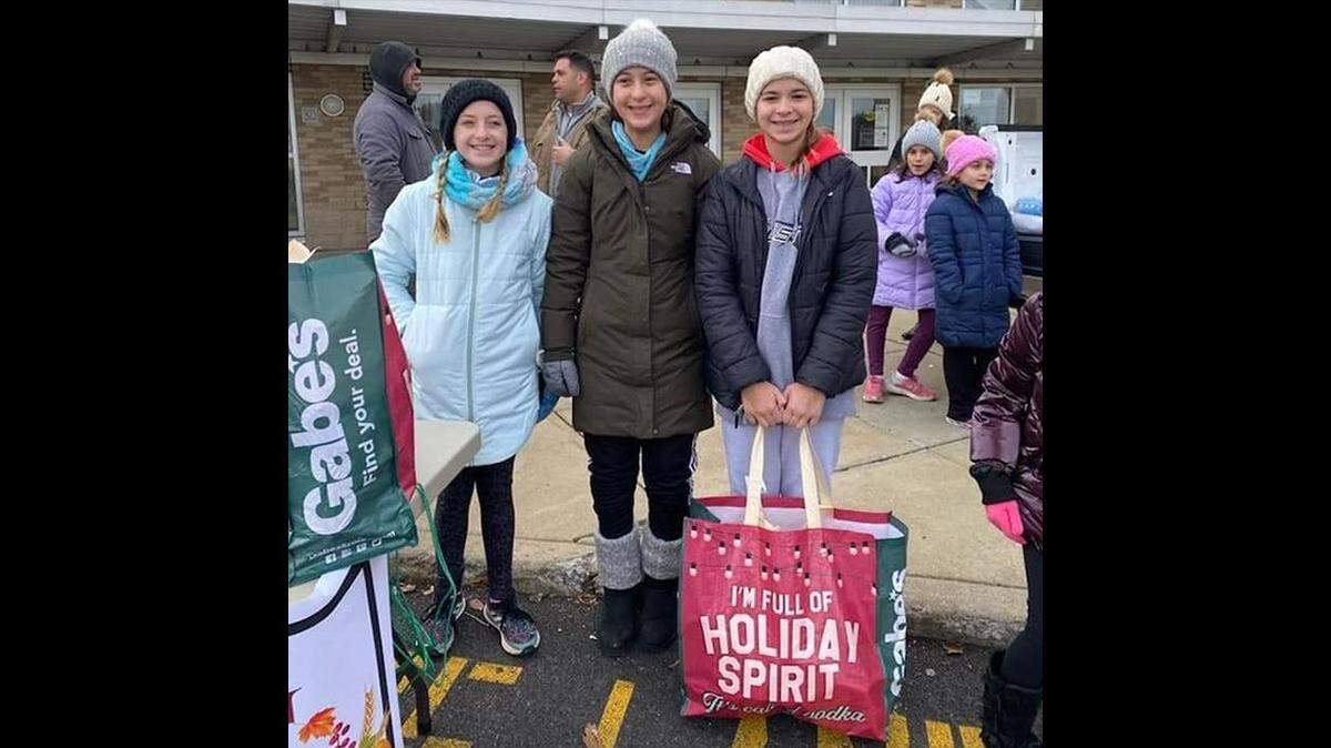 Boo Squad members, from left, Madison Medvec, Giada DeSantis and Angela Bettura help load Thanksgiving meals into families’ cars during a past event.