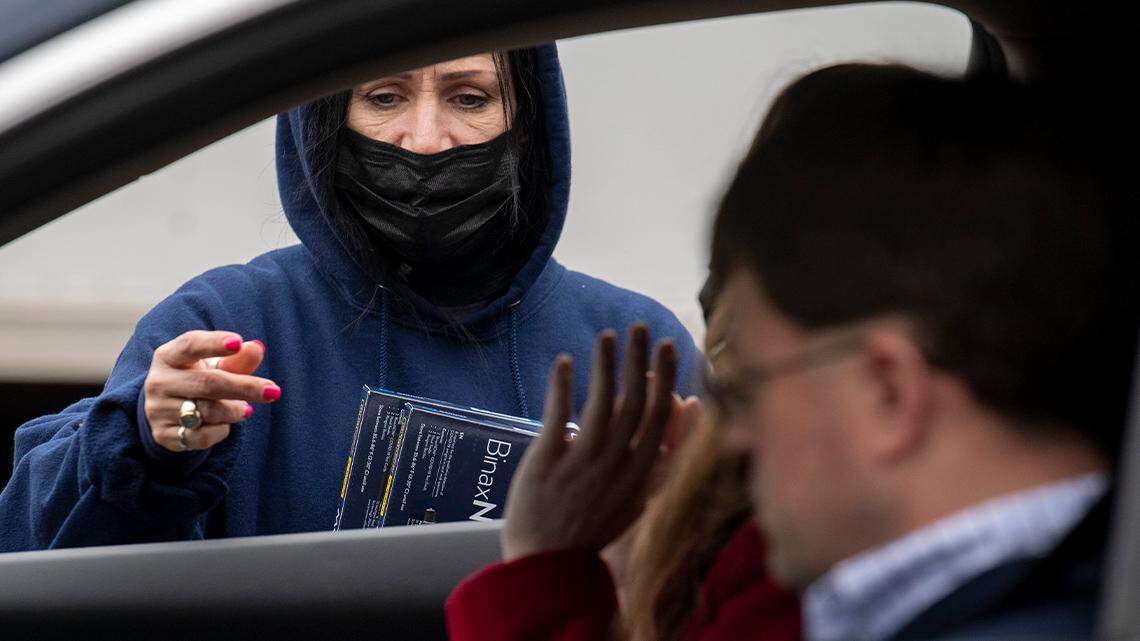Youngstown City Health Department worker Kathy Johnson talks with drivers before giving them at-home COVID-19 test kits during a distribution event in Youngstown on Dec. 30, 2021.