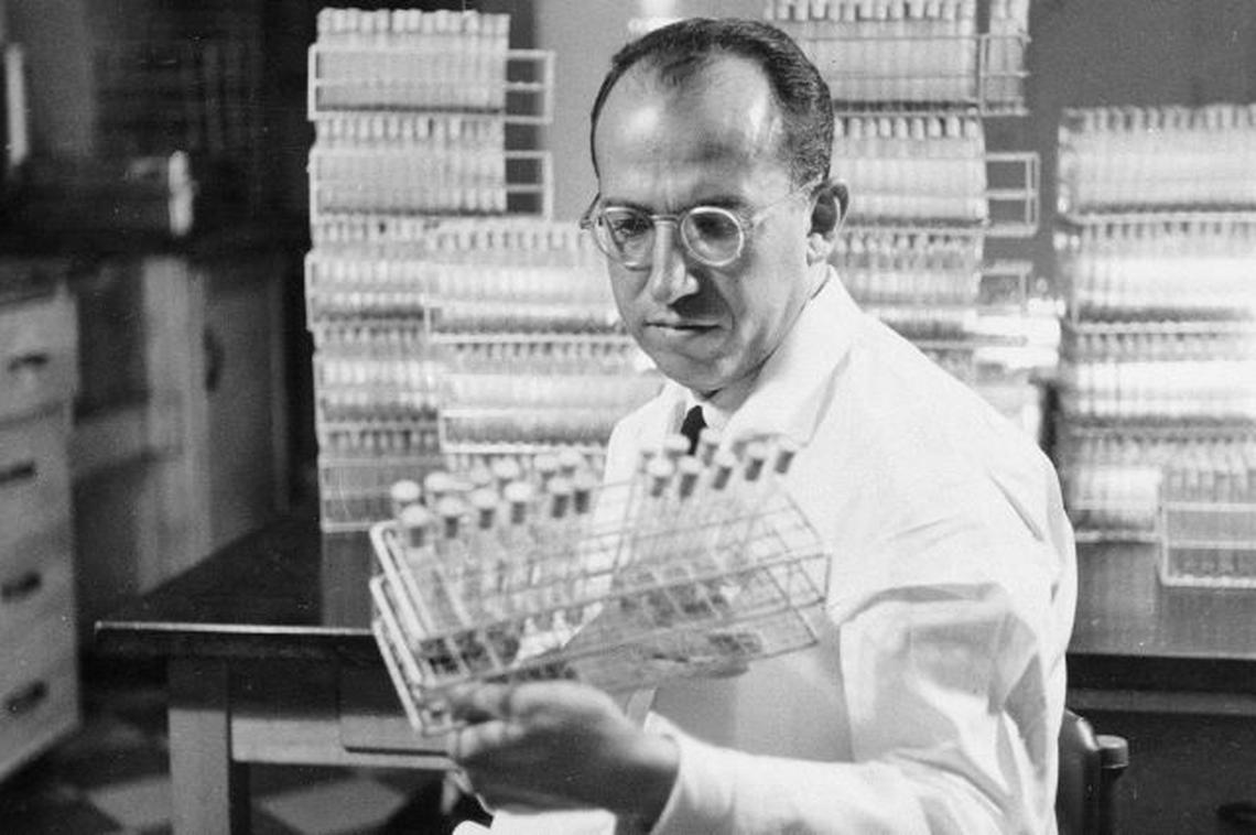 In this Oct. 7, 1954, file photo, Dr. Jonas Salk, developer of the polio vaccine, holds a rack of test tubes in his lab in Pittsburgh.