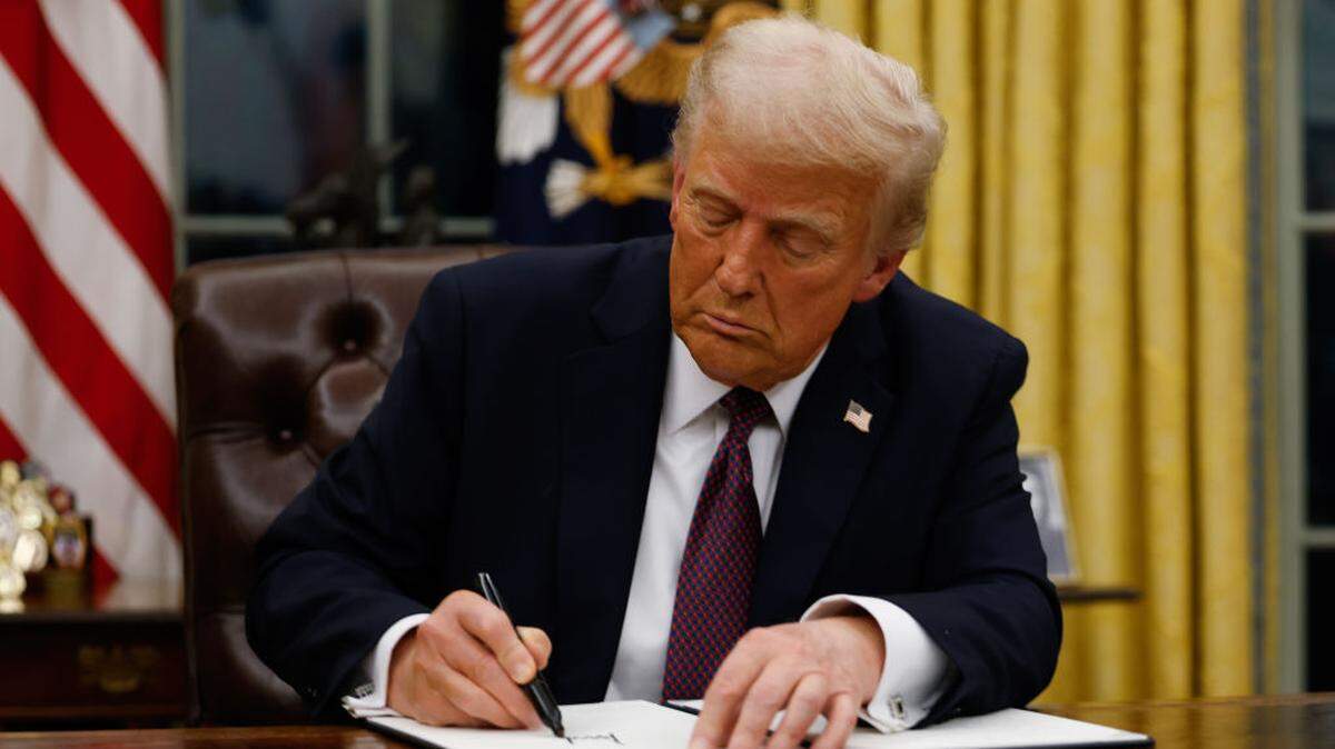 President Donald Trump signs executive orders in the Oval Office of the White House.