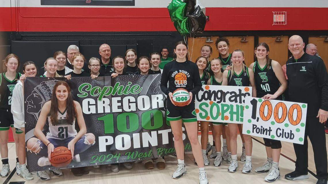 West Branch High School’s Sophie Gregory is pictured with team members after scoring her 1,000th point in the Warriors’ 40-34 win over arch-rival Salem Wednesday night.