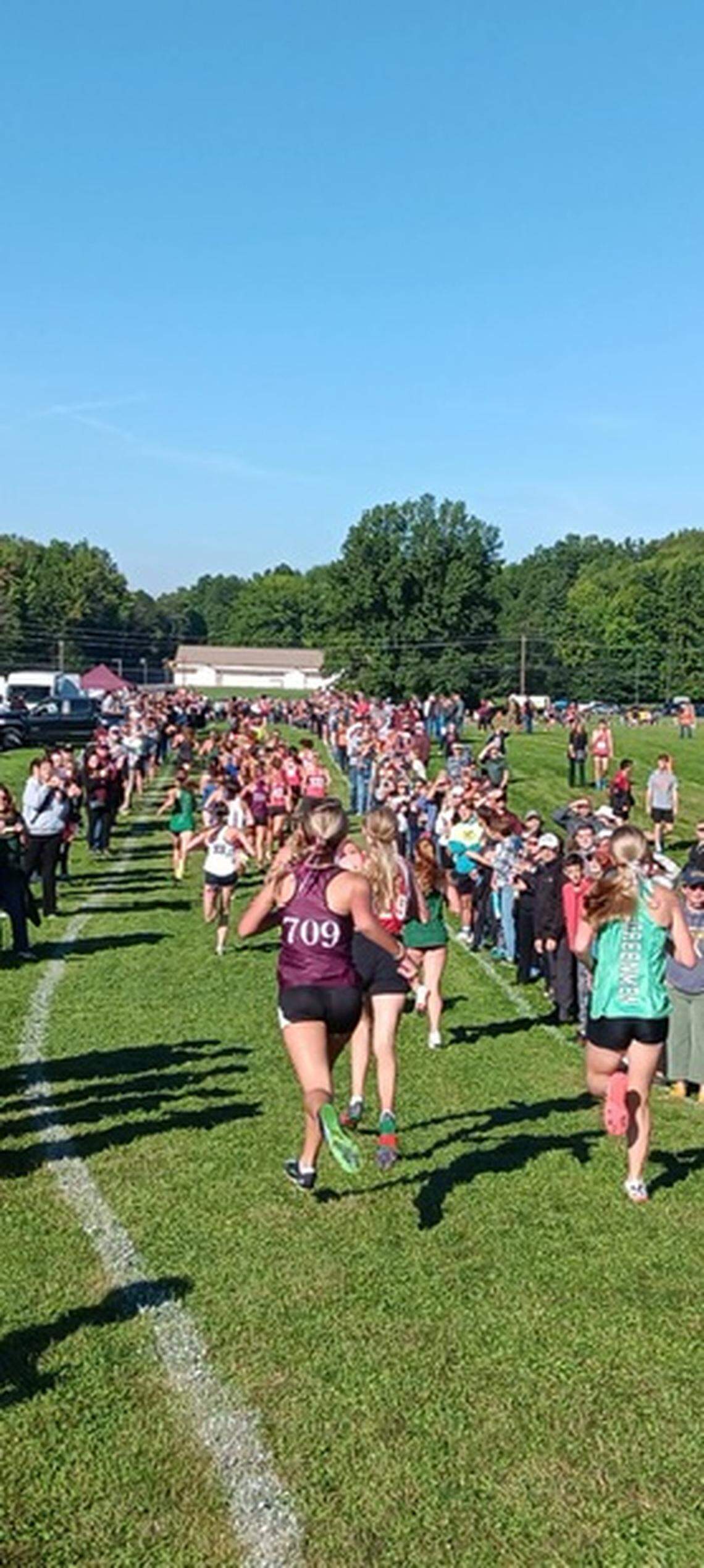 Runners race down the hill in the girls’ race as hundreds of fans look on during Saturday’s annual Boardman Spartan Invitational.