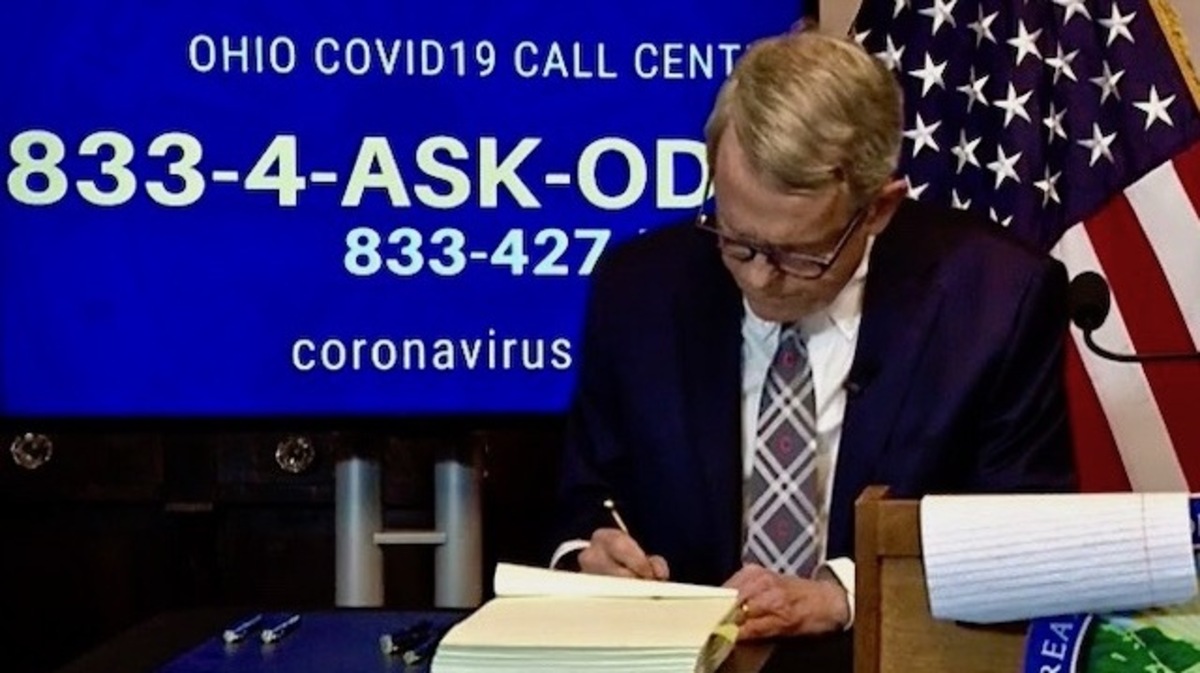 Gov. Mike DeWine signs the state's coronavirus relief bill.