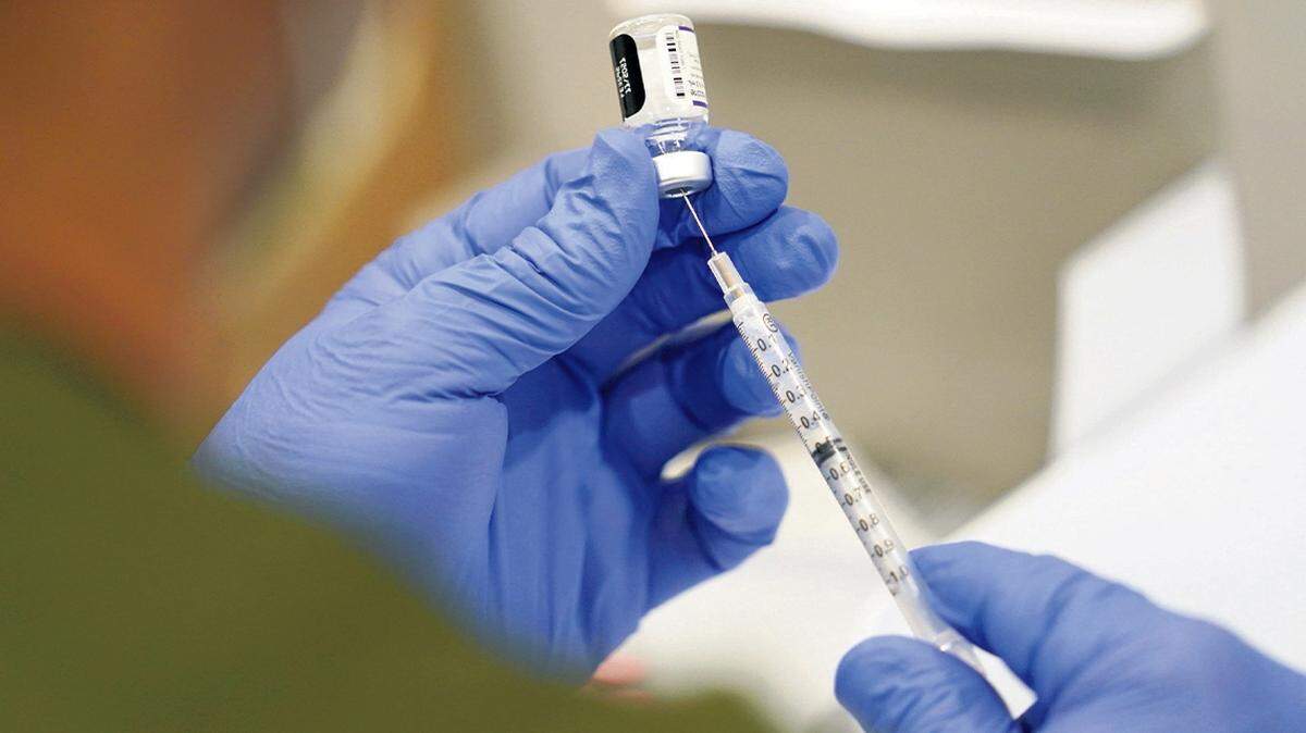 A health care worker fills a syringe with the Pfizer COVID-19 vaccine at Jackson Memorial Hospital in Miami in October 2021.
