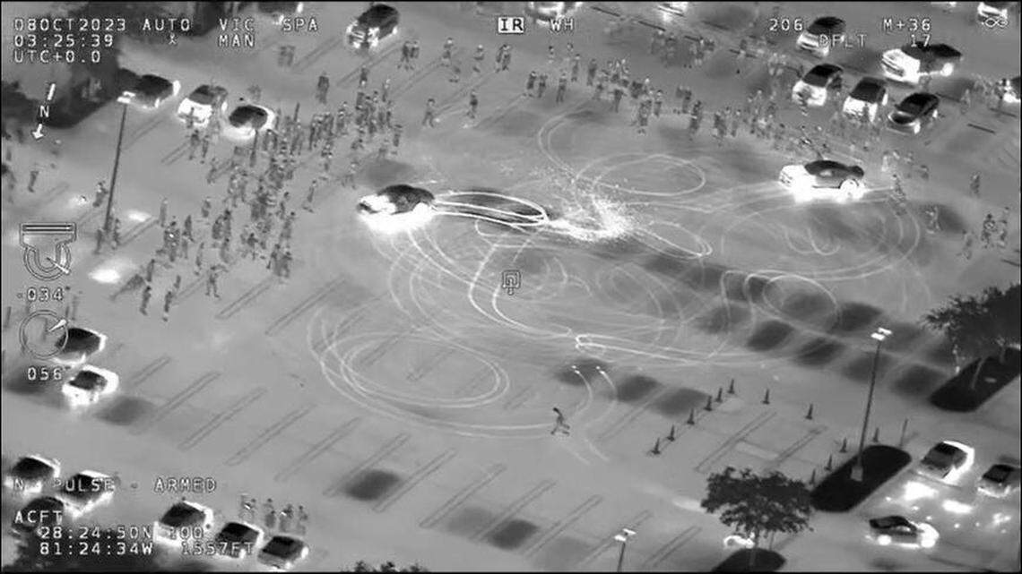 An infrared image shows cars doing burnouts in a parking lot.