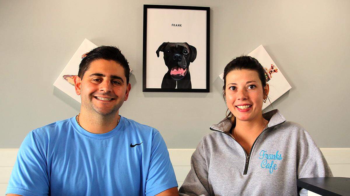 Shown here are Raphe Neapolitan (left) and Danielle Davis, owners of Frank’s Cafe along Market Street in Boardman, which officially opened Friday, April 29, 2022. The cafe is named for their dog Frank, pictured behind them.