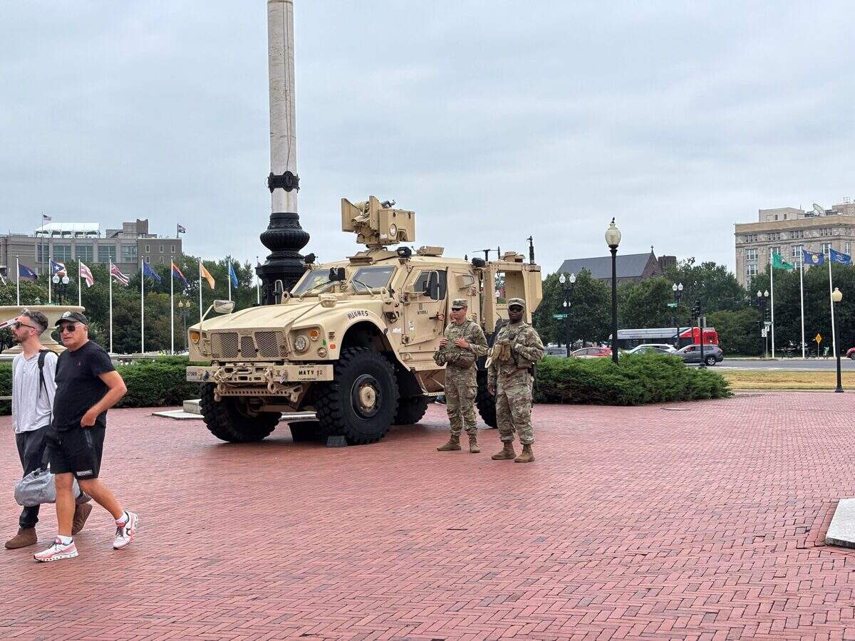 Tourists pass by members of the National Guard stationed outside Union Station in Washington, D.C.
