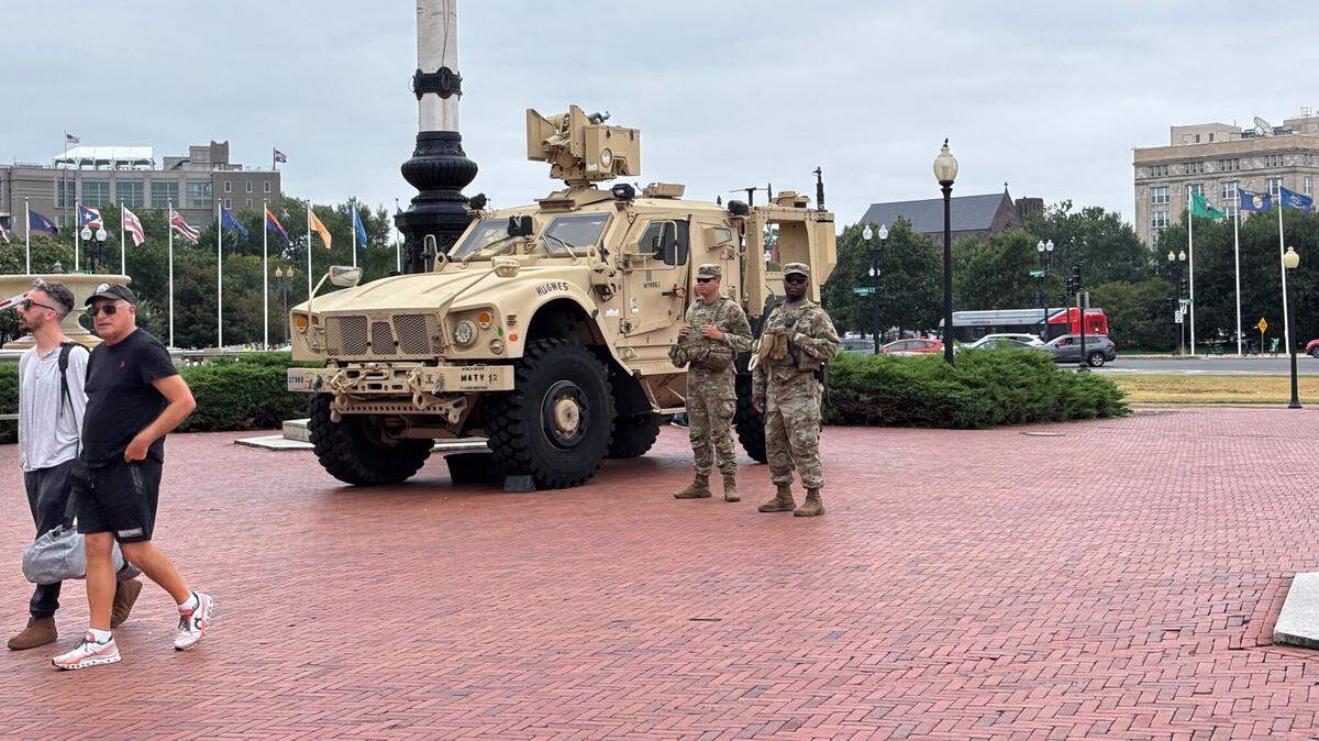 Tourists pass by members of the National Guard stationed outside Union Station in Washington, D.C.