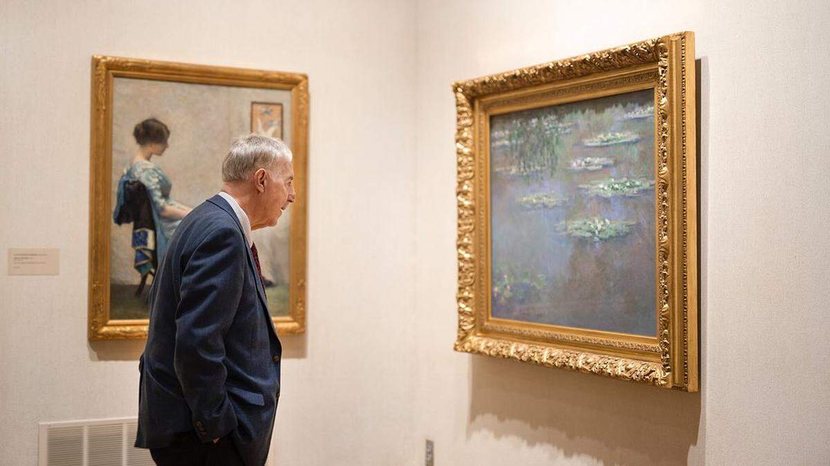 Lou Zona, executive director of the Butler Institute of American Art views Monet’s “Nymphéas” painting.