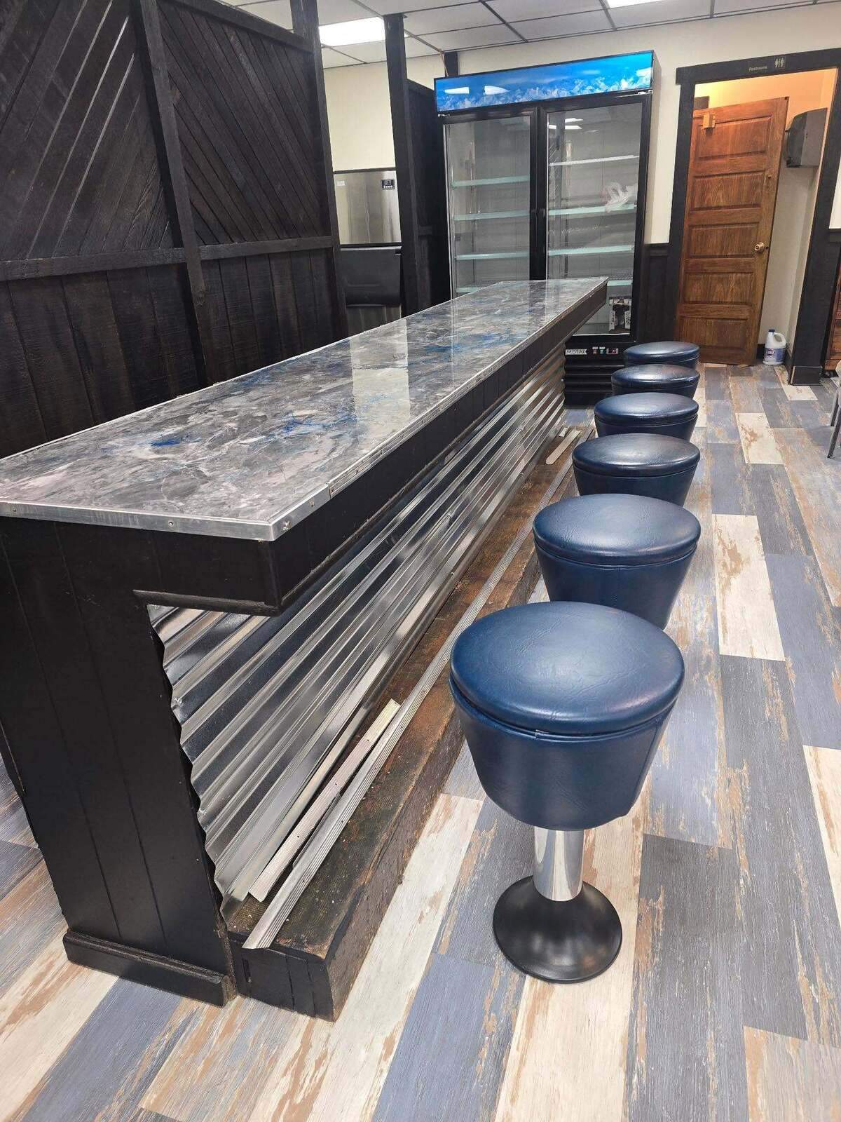 There’s a fresh, hand-painted sign welcoming new and regular customers, as well as a newly refinished bar top with replaced bar stools.