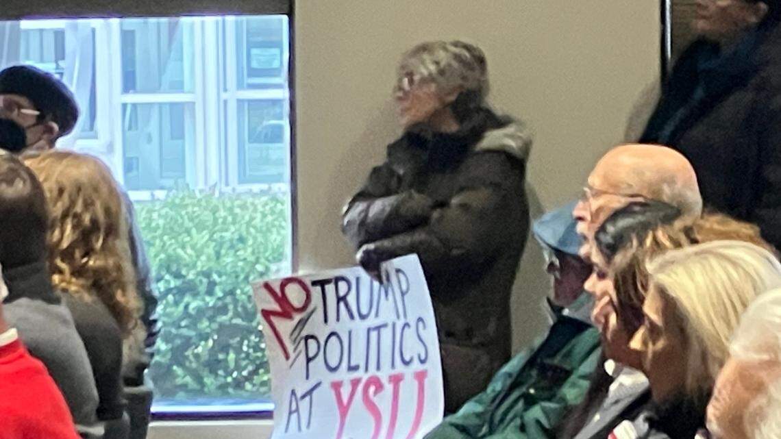 A woman holds a sign sharing her opposition to Youngstown State hiring U.S. Rep. Bill Johnson as the school’s next president.