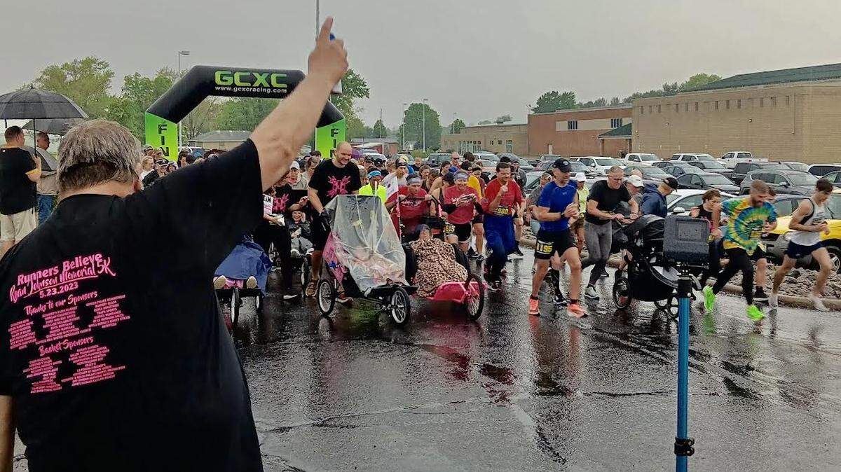 Roy Johnson, left, the father of the late Ryan Johnson, presses the air horn starting the 15th annual Ryan Johnson Memorial 5K run/walk Saturday at West Branch High School. A total of 113 runners took part in the event.