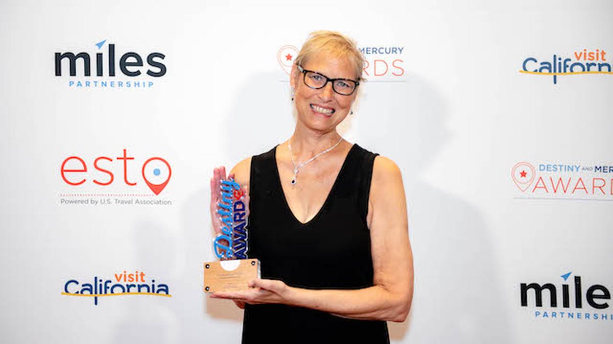 Beth Kotwis Carmichael, Trumbull County Tourism executive director,  shows off the 2021 Destiny Award presented by the U.S. Travel Association that the agency won for its 2020 Trumbull County Visitors Guide. (Photo provided)
