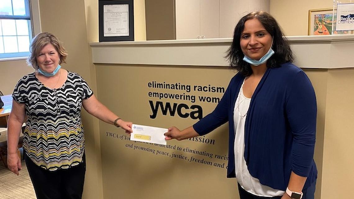 Judy Radkowski (left), the director of community donor engagement for the Community Foundation of Western Pennsylvania and Eastern Ohio, presents a donation check to Varada Bhide, COO for YWCA Mahoning Valley. (Photo contributed by YWCA).