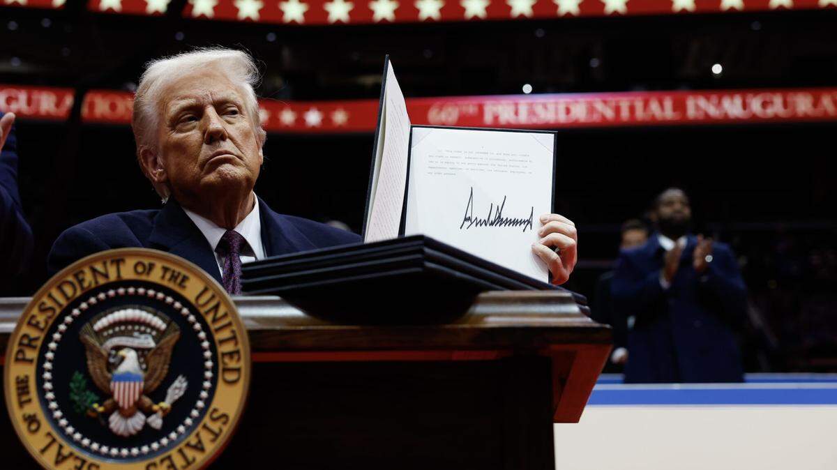 President Donald Trump holds up an executive order after signing it during an indoor inauguration parade at the Capital One Arena on Jan. 20, 2025, in Washington, D.C.