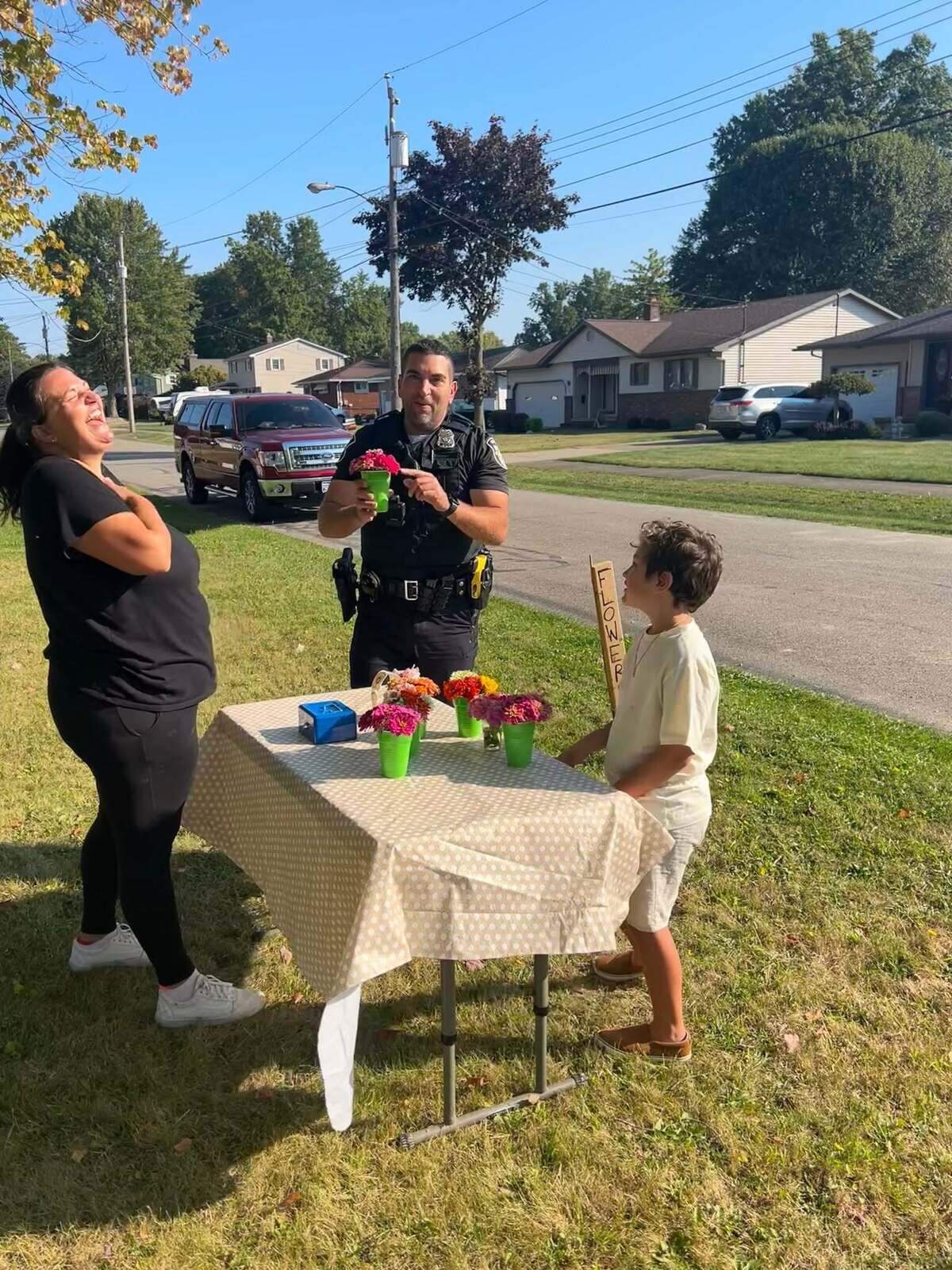 Local officers supporting Mandi Clark and her son, Evander, selling floral arrangements from their roadside stand in 2024.